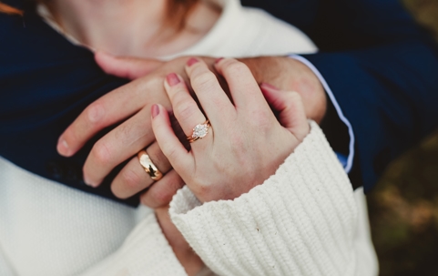 couple hugging and showing off rings